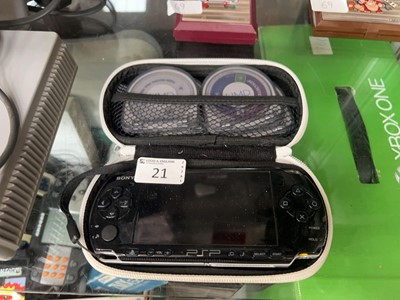 Lot 21 - A cased PSP model 3003 console with four games...