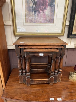 Lot 26 - An oak nest of three occasional tables on...
