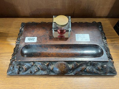 Lot 1042 - Carved oak ink stand with glass ink well