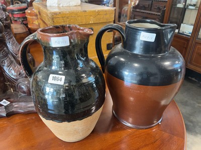 Lot 1064 - 2 single handled ceramic jugs - 1 in dark...