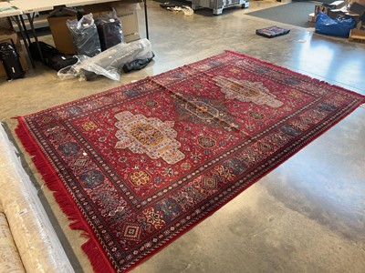 Lot 1406 - Tunisian figured and bordered rug on a red ground