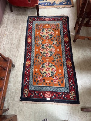 Lot 32 - An eastern style orange ground hand woven rug...