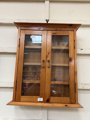 Lot 57 - A waxed pine wall mounted display cabinet