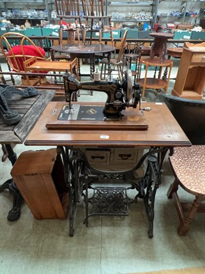 Lot 64 - An oak cased manual sewing machine along with...