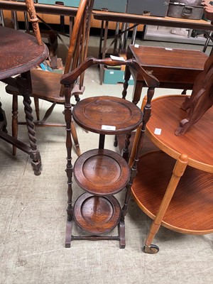 Lot 86 - An oak three tier folding cake stand on turned...