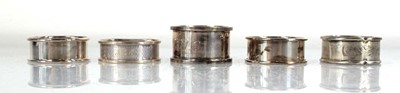 Lot 345 - Five silver napkin rings, various designs,...