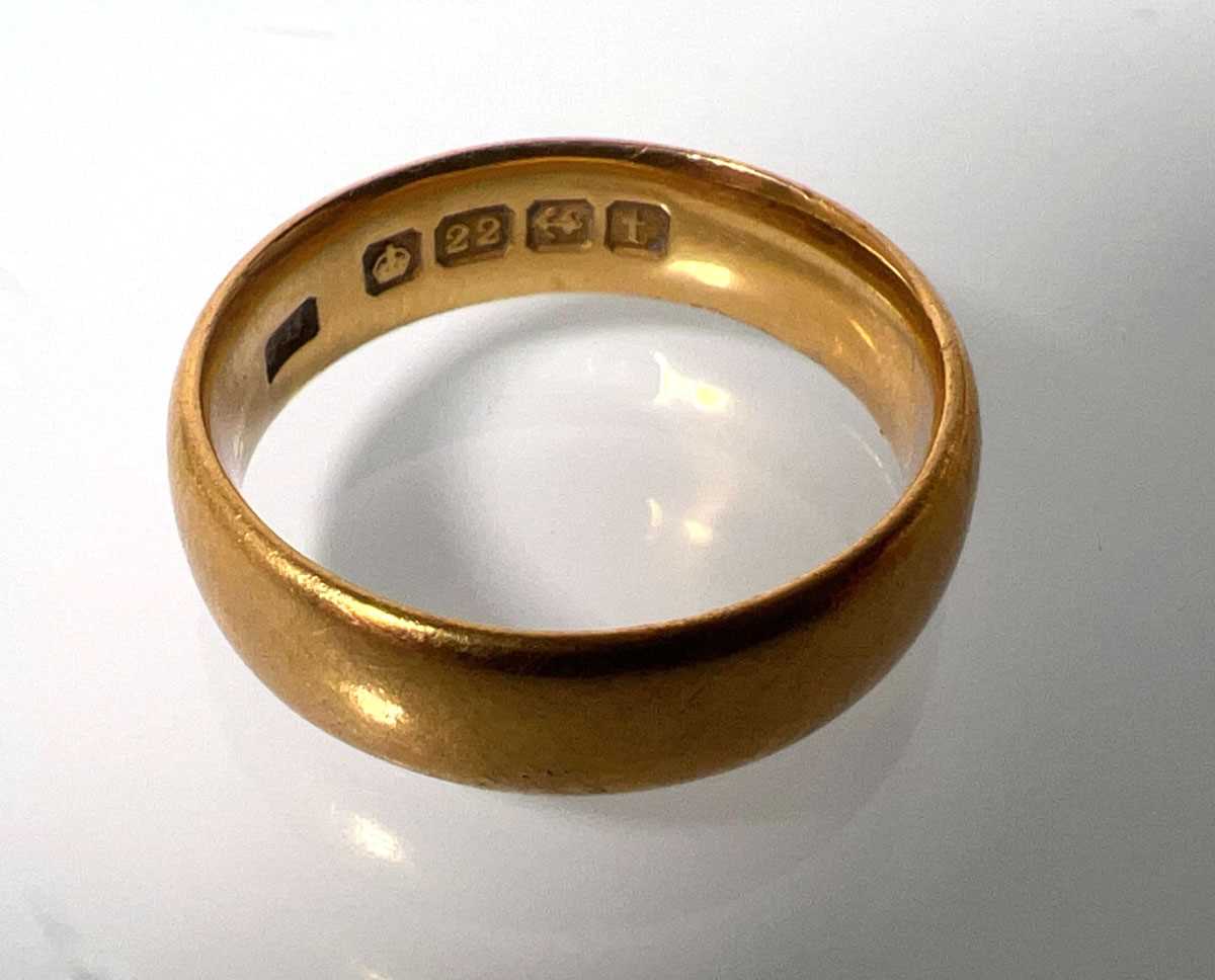 Lot 423 - A 22ct gold 'D' shaped wedding band. Approx....