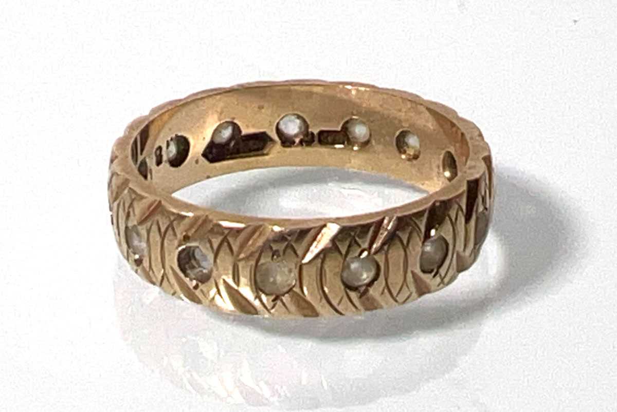 Lot 438 - A 9ct gold patterned eternity ring set with...