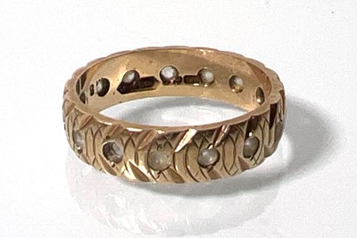 Lot 438 - A 9ct gold patterned eternity ring set with...