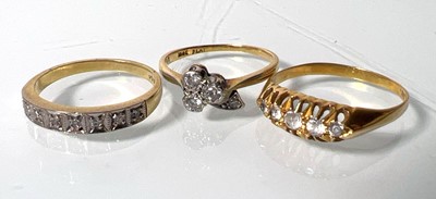 Lot 439 - An 18ct gold channel set diamond ring together...