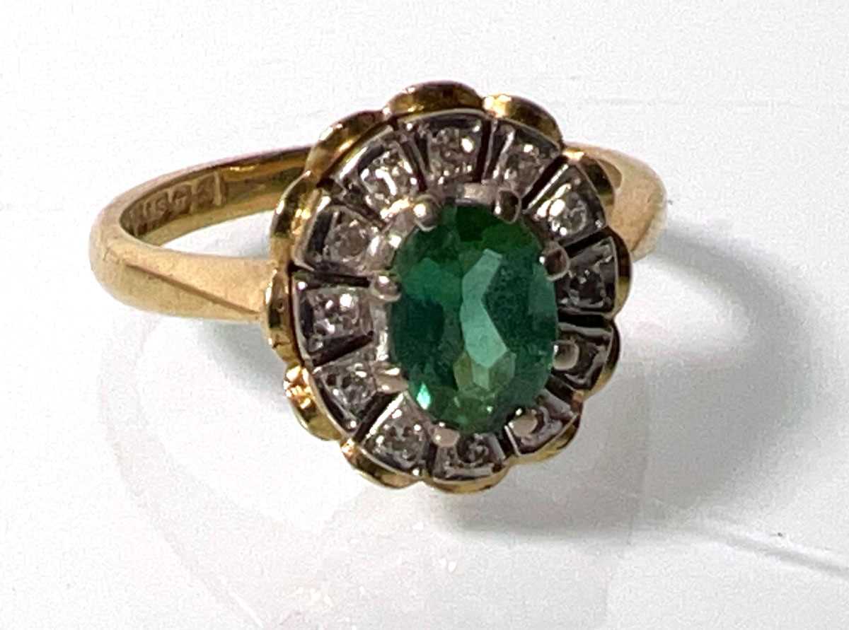 Lot 442 - An 18ct gold, emerald and diamond cluster ring....