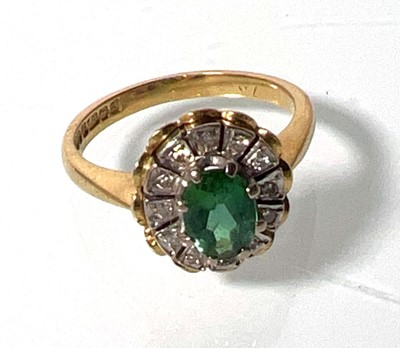 Lot 442 - An 18ct gold, emerald and diamond cluster ring....