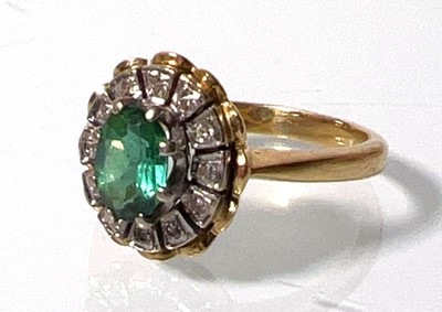 Lot 442 - An 18ct gold, emerald and diamond cluster ring....