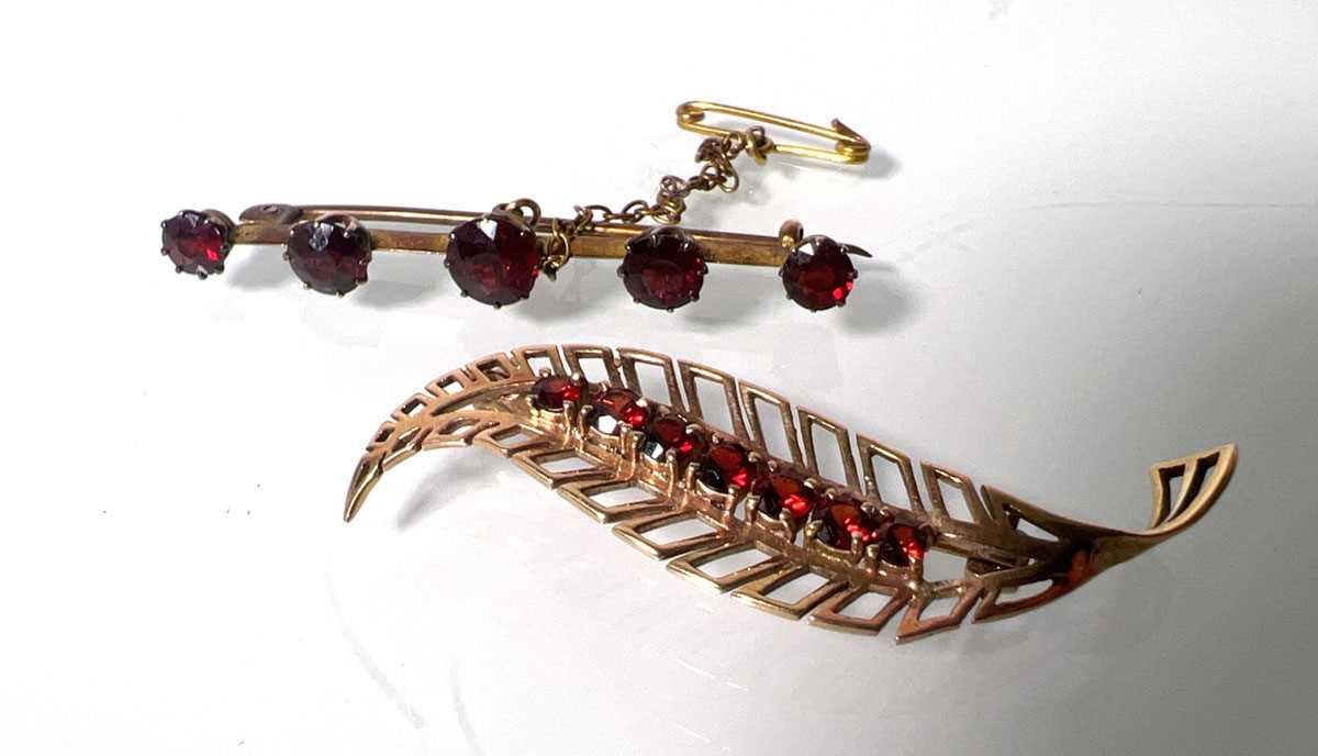 Lot 457 - A yellow metal and garnet leaf brooch marked...