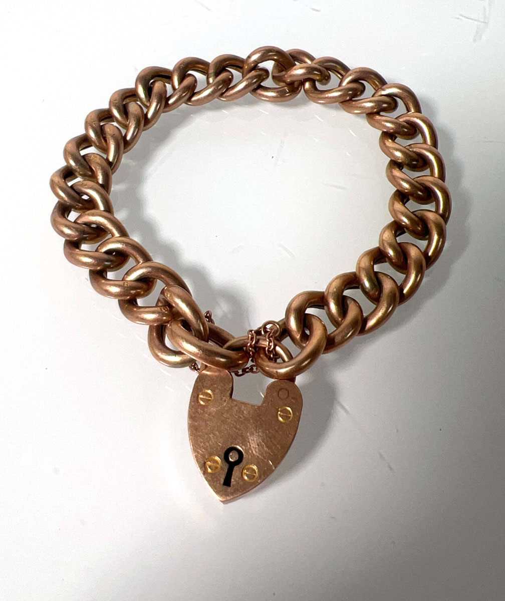 Lot 476 - A yellow metal curb link bracelet with heart...