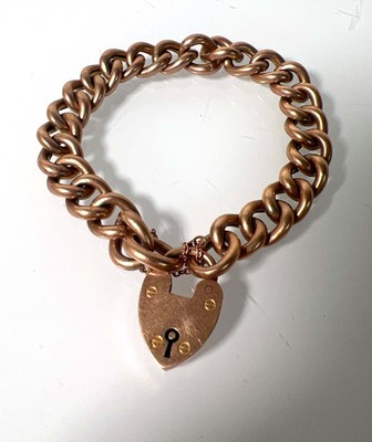 Lot 476 - A yellow metal curb link bracelet with heart...