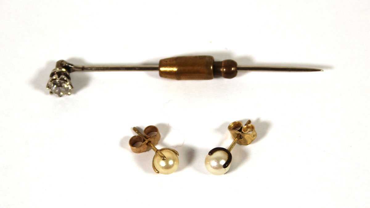 Lot 493 - A white metal and diamond stick pin, the round...