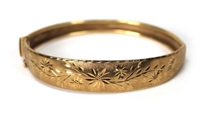 Lot 564 - A 9ct yellow gold florally engraved hinged...