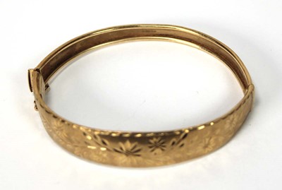 Lot 564 - A 9ct yellow gold florally engraved hinged...