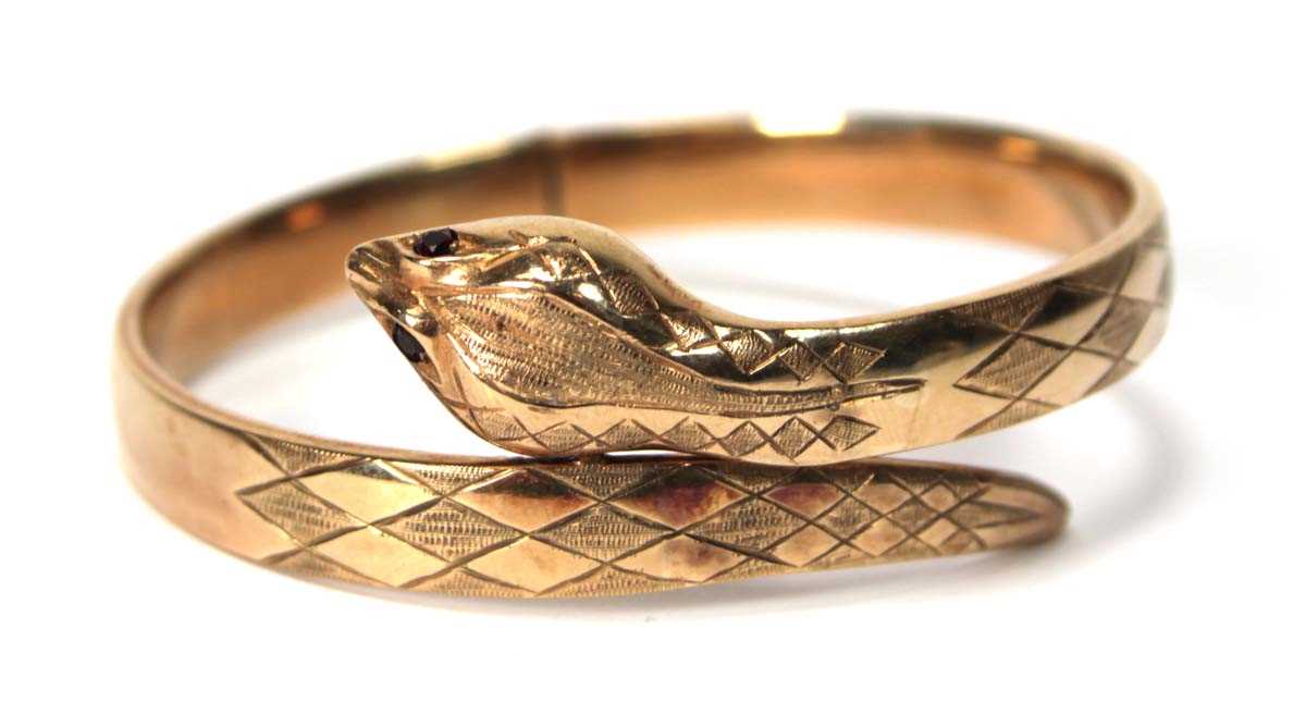Lot 594 - A 9ct yellow gold hinged bracelet of serpent...