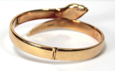 Lot 594 - A 9ct yellow gold hinged bracelet of serpent...