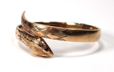Lot 594 - A 9ct yellow gold hinged bracelet of serpent...