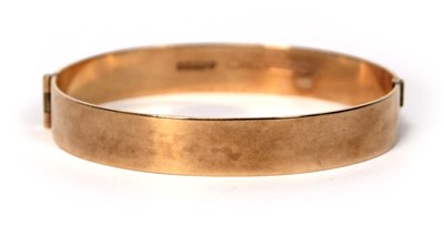 Lot 597 - A 9ct yellow gold hinged bracelet with bark...