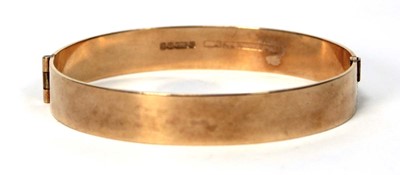 Lot 597 - A 9ct yellow gold hinged bracelet with bark...