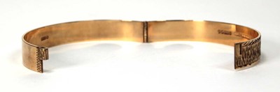 Lot 597 - A 9ct yellow gold hinged bracelet with bark...