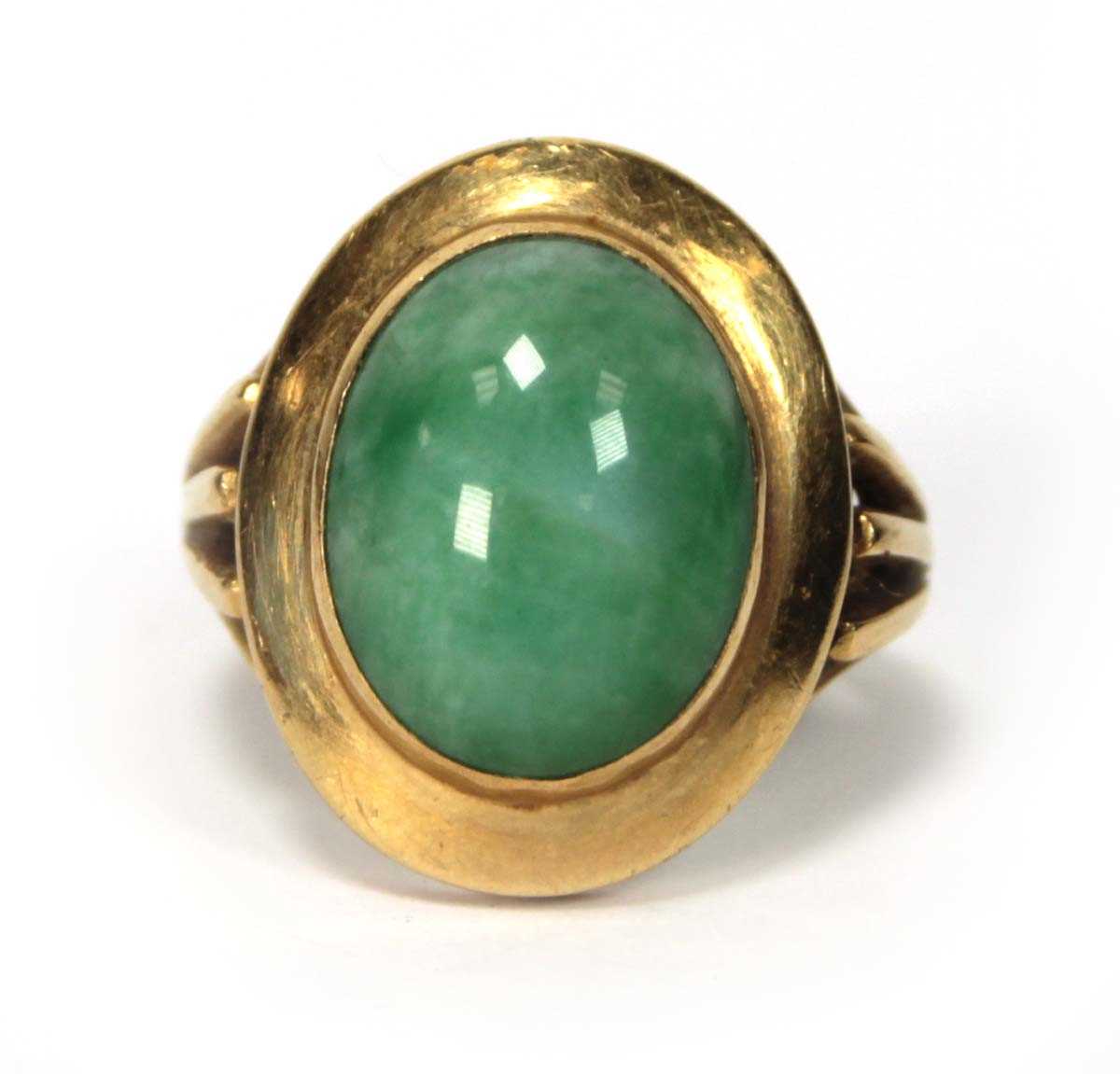 Lot 606 - An 18ct yellow gold ring set cabochon green...