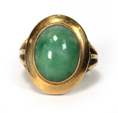 Lot 606 - An 18ct yellow gold ring set cabochon green...