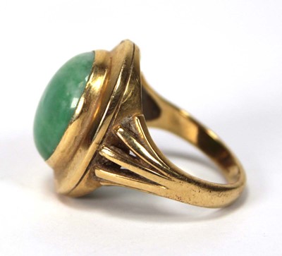 Lot 606 - An 18ct yellow gold ring set cabochon green...