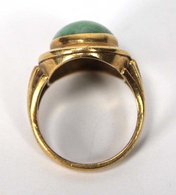 Lot 606 - An 18ct yellow gold ring set cabochon green...