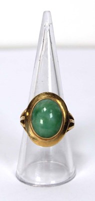 Lot 606 - An 18ct yellow gold ring set cabochon green...