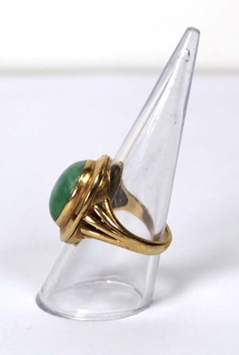 Lot 606 - An 18ct yellow gold ring set cabochon green...