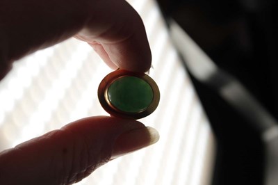 Lot 606 - An 18ct yellow gold ring set cabochon green...