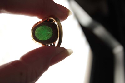 Lot 606 - An 18ct yellow gold ring set cabochon green...