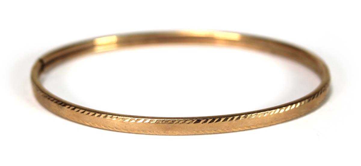 Lot 615 - A 9ct yellow gold hollow hinged bracelet,...