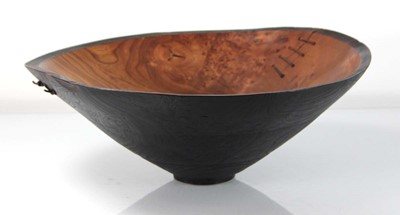 Lot 89 - A turned wooden bowl with leather straps by...