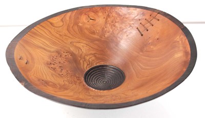 Lot 89 - A turned wooden bowl with leather straps by...