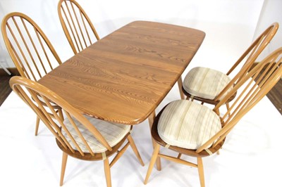 Lot 64 - An Ercol elm drop-leaf dining table on beech...