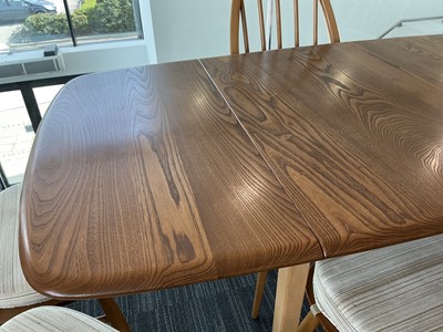 Lot 64 - An Ercol elm drop-leaf dining table on beech...