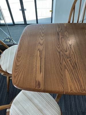 Lot 64 - An Ercol elm drop-leaf dining table on beech...