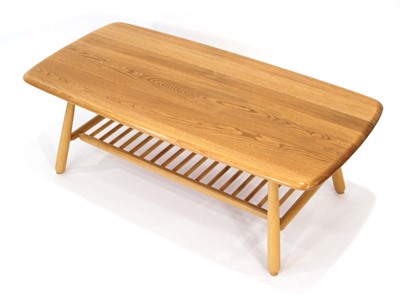 Lot 66 - An Ercol elm coffee table of cushioned...