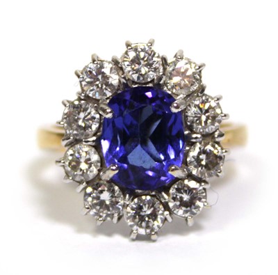 Lot 622 - An 18ct yellow gold cluster ring set oval blue...