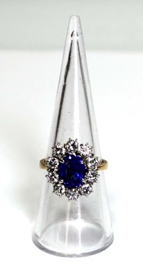 Lot 622 - An 18ct yellow gold cluster ring set oval blue...