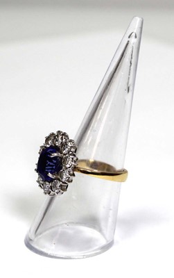 Lot 622 - An 18ct yellow gold cluster ring set oval blue...