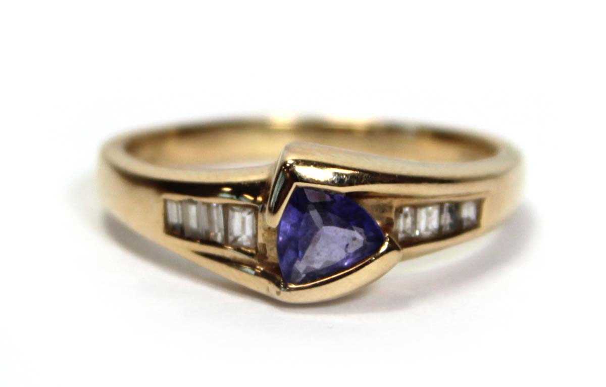Lot 638 - A 14ct yellow gold ring set a trillion cut...
