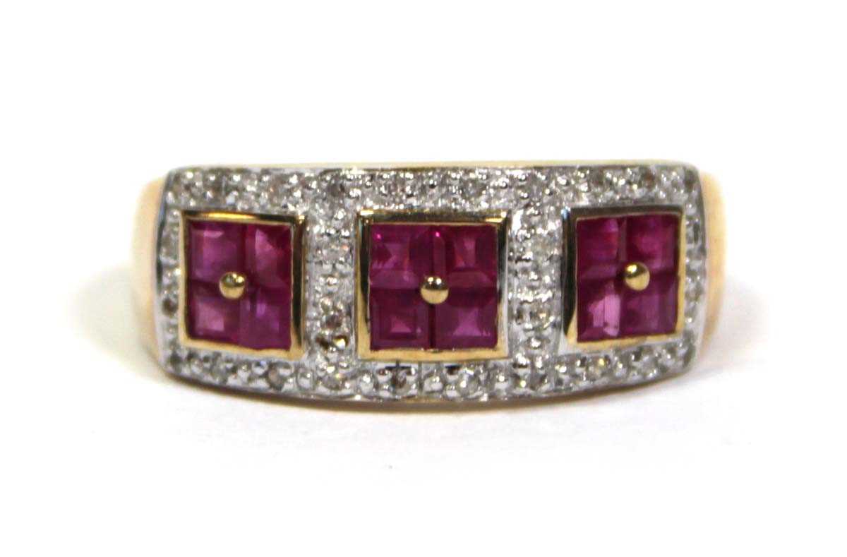 Lot 661 - A 9ct yellow gold ring set three ruby clusters...