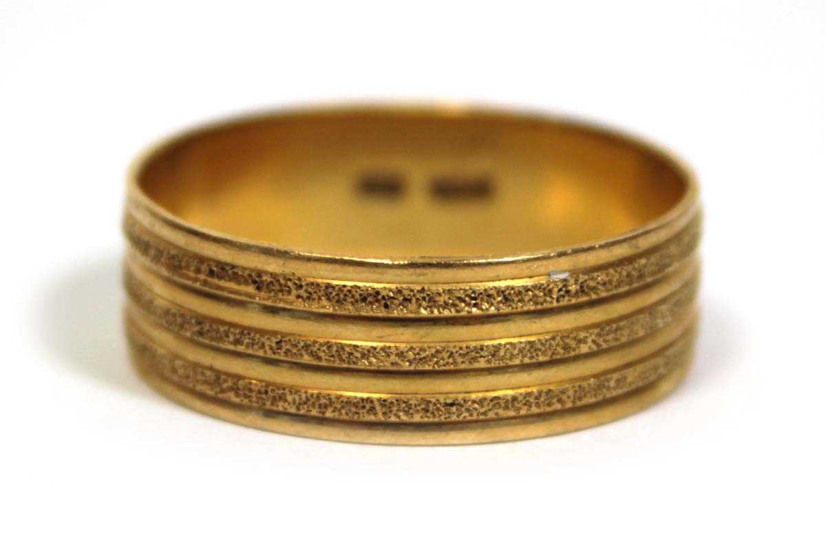 Lot 670 - A 22ct yellow gold textured wedding band, band...